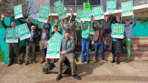 Green candidates for Mid Suffolk Green Party holding up 'Vote Green' signs outside The Mix in Stowmarket